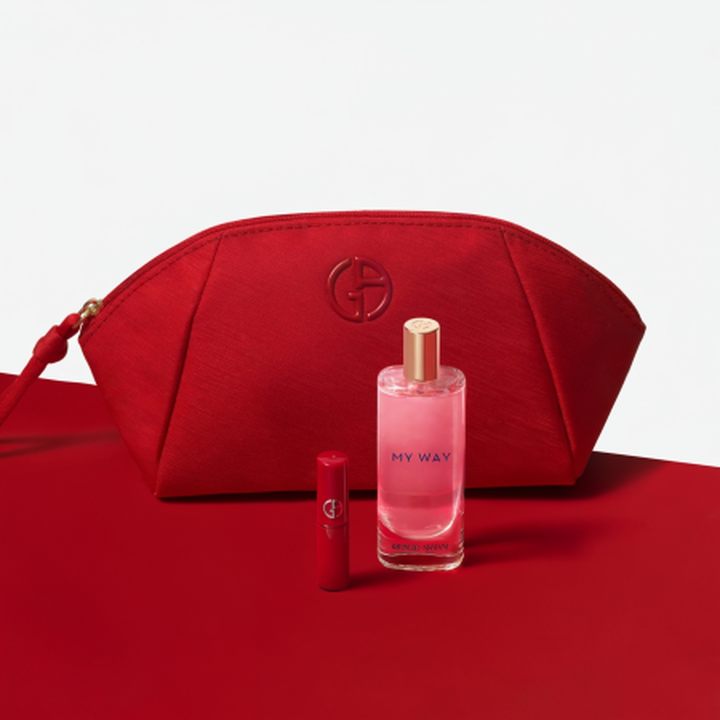 In einer Hand halt er Si Passione, wahrend auf dem roten Zahler ADGH PROFONDO EDP und eine schwarze Tasche zu sehen sind.