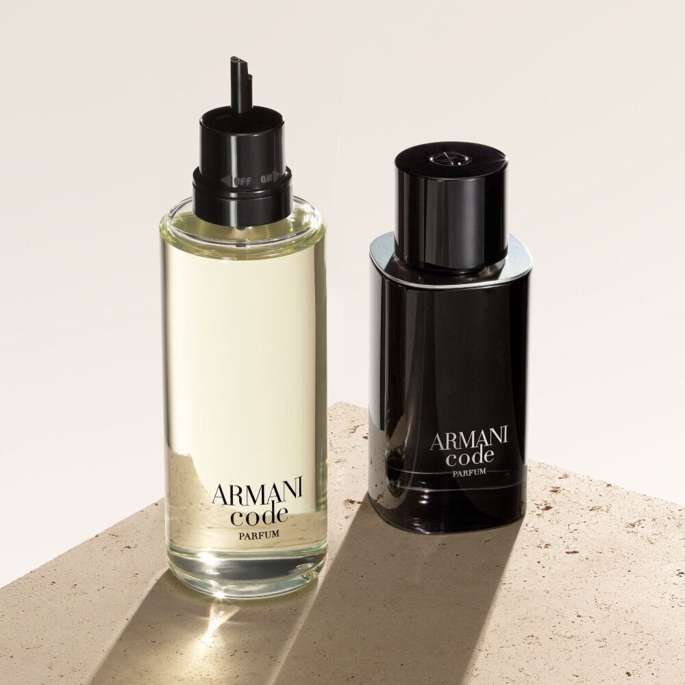 Zwei Flakons Armani Code Parfum werden vor einem strukturierten, beigen Hintergrund prasentiert. Die Flasche links ist eine Nachfullung mit leichterer, transparenter Optik, wahrend rechts die klassische, undurchsichtige schwarze Flasche des Duftes zu sehen ist.