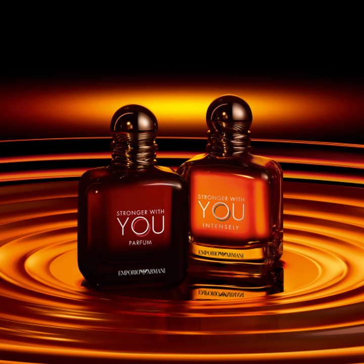 Flacons Emporio Armani Stronger With You Parfum et Stronger With You Intensely, tons ambres chauds sur fond de vagues dorees tourbillonnantes​