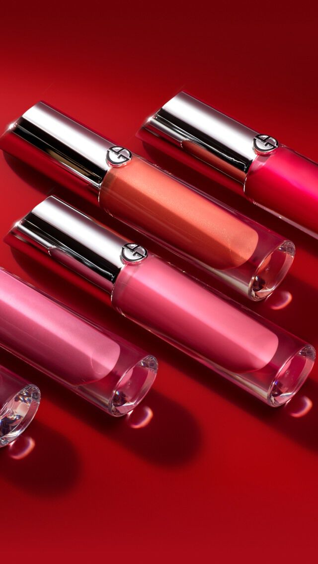 Funf Lippenstifte in verschiedenen Rosa- und Rottonen auf einem roten Hintergrund.