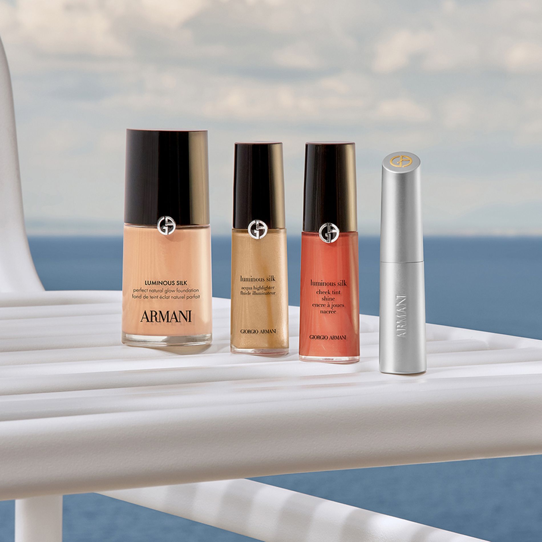 Un rituel de beaute sophistique : Fond de Teint Luminous Silk, Correcteur, Encre a Joues et rouge a levres. Poses sur un yacht face a la mer, ces icones promettent un eclat naturel et aerien pour une escapade cotiere luxueuse.