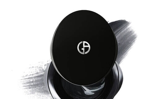 Un boitier noir elegant avec un logo argente sur le dessus, reposant sur une fond de texture grise.