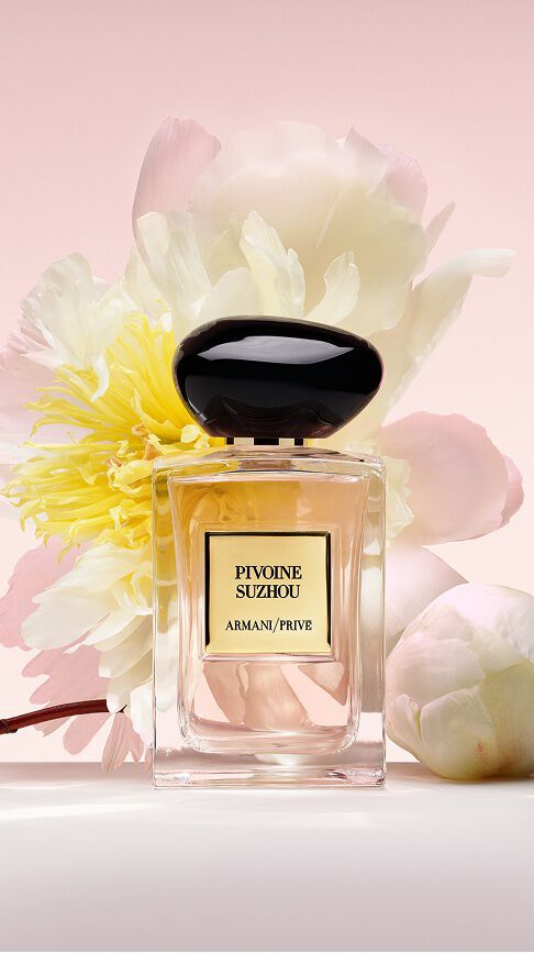 Armani/Prive Pivoine Suzhou: ein Glasflakon mit zartrosa Duft, gebettet in uppige weiße und gelbe Pfingstrosen, der die Anmut und strahlende Schonheit der Natur feiert.