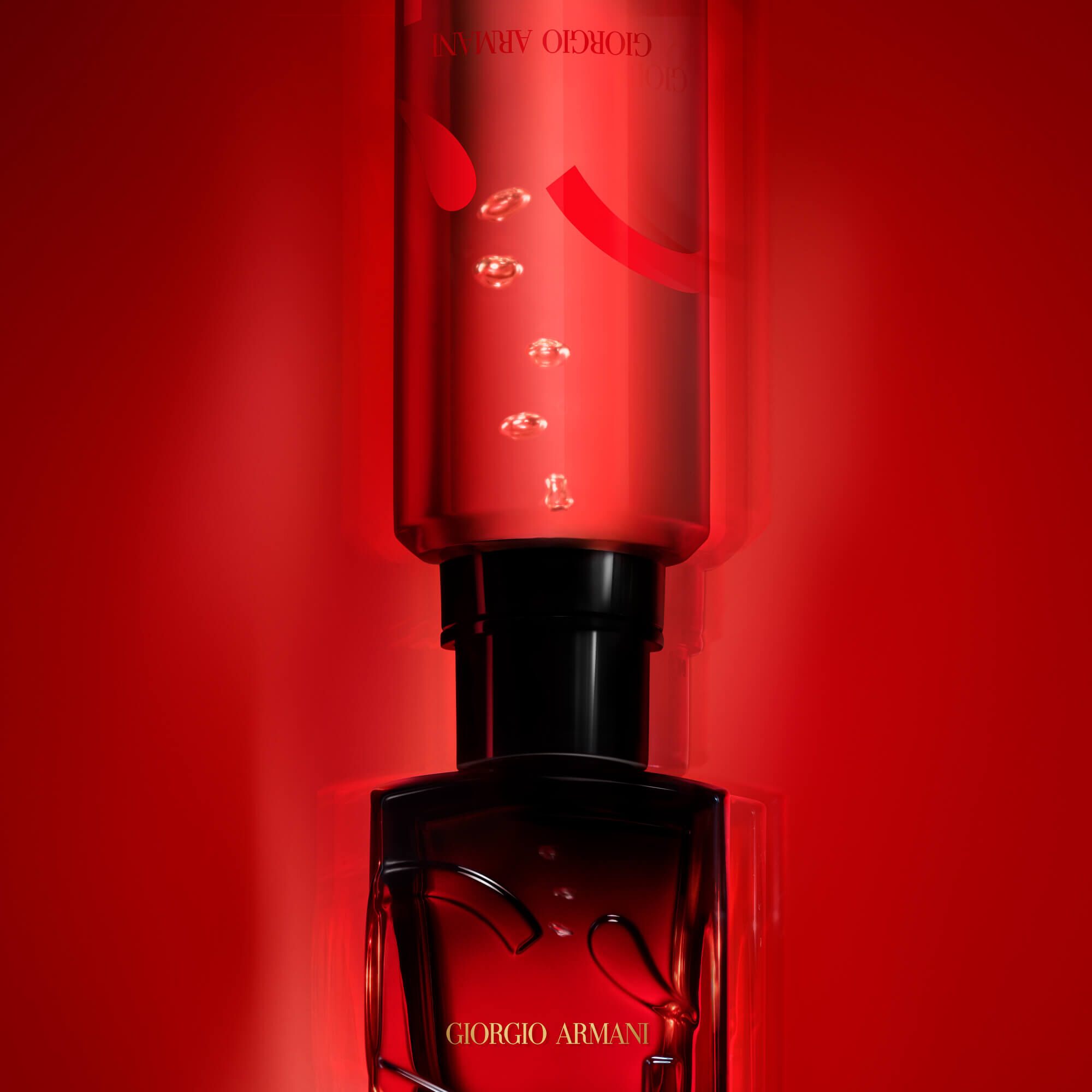 Un flacon de parfum rouge avec des gouttes visibles a l'interieur, sur un fond rouge.