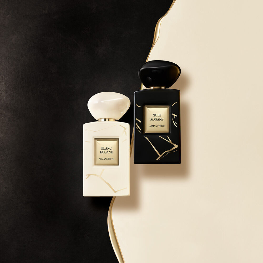 Two elegantly designed perfume bottles, one white and one black, displayed on a soft, neutral background.