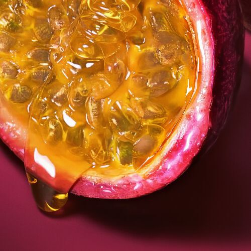 Halved maracuja passion fruit on a deep ruby background — maracuja accord top note of Power of You Eau de Parfum by Giorgio Armani.