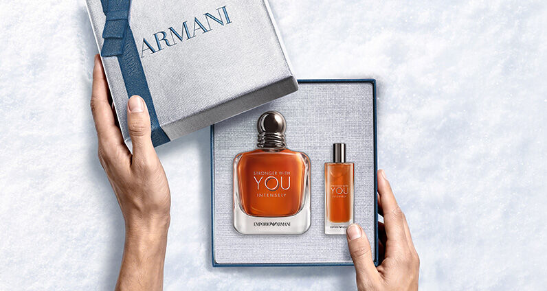 Flacon de parfum Giorgio Armani « Acqua di Gio » avec un coffret cadeau Armani bleu texture.