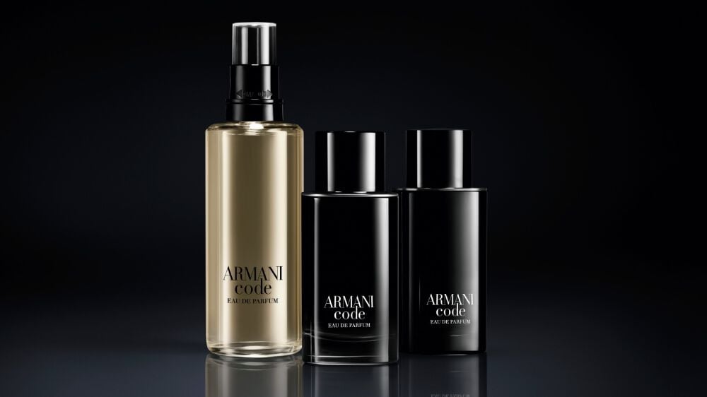 Drei Parfümflaschen von Armani Code auf schwarzem Hintergrund: eine große und zwei kleinere, elegant gestaltet.