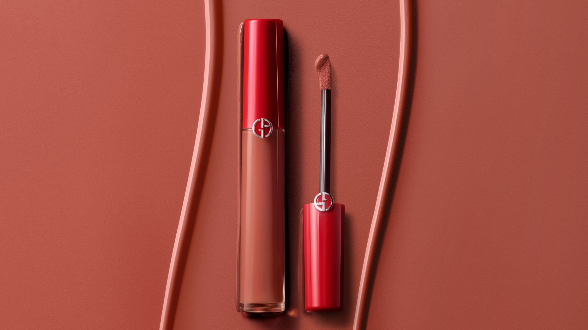 Flüssiger Lippenstift von Giorgio Armani mit Applikator auf texturiertem Terrakotta-Hintergrund.