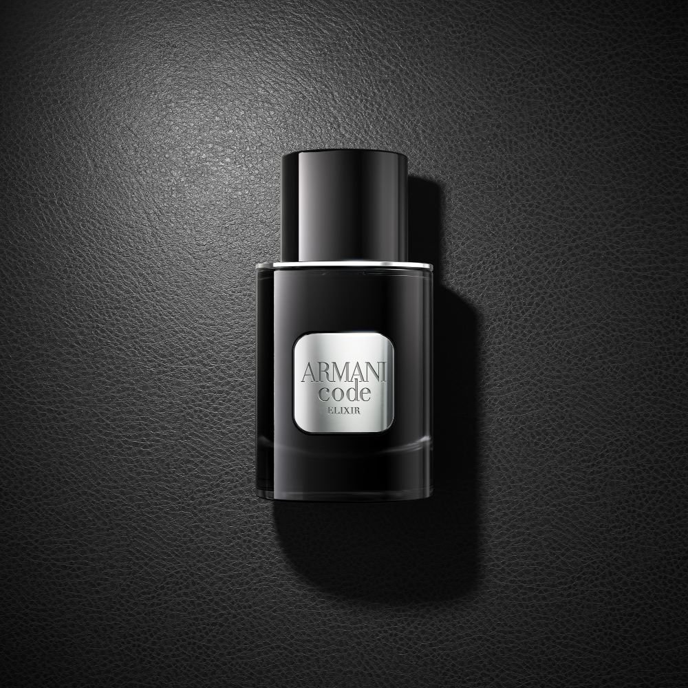 Ein schwarzer Flakon des Parfums Armani Code Elixir ruht elegant auf einer passenden schwarzen Oberfläche und schafft einen raffinierten monochromen Look